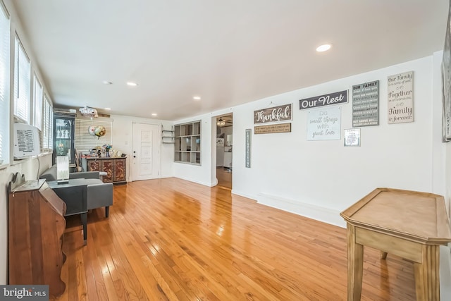 living room featuring light wood-style floors, recessed lighting, and cooling unit