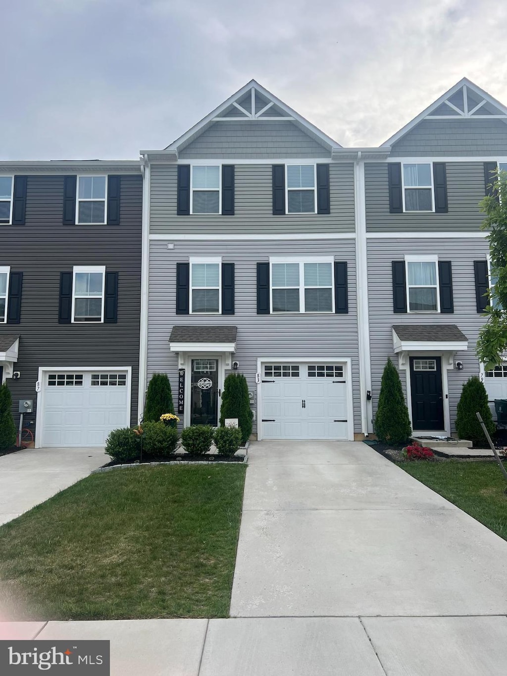 townhome / multi-family property featuring driveway, a garage, and a front yard