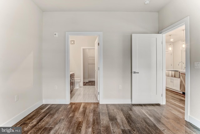 1761 Old Meadow Rd Unit 209, Mclean, VA 22102 - unfurnished bedroom featuring a sink, wood finished floors, connected bathroom, and baseboards