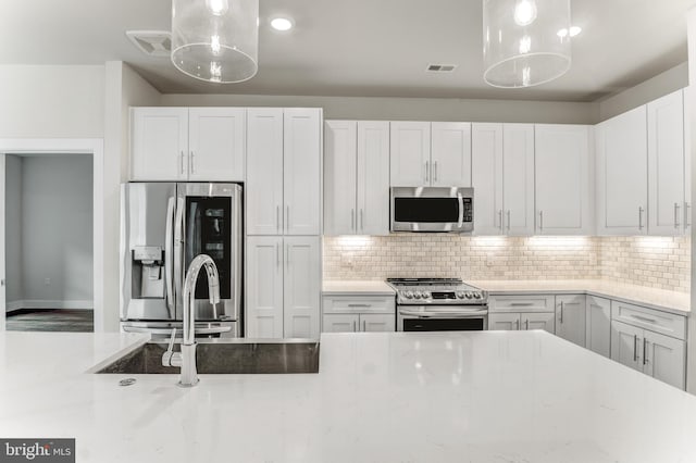1761 Old Meadow Rd Unit 209, Mclean, VA 22102 - kitchen with appliances with stainless steel finishes, backsplash, decorative light fixtures, white cabinetry, and light stone countertops
