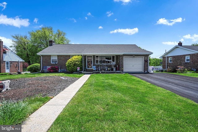 ranch-style house featuring a garage, brick siding, a front yard, driveway, and a porch
