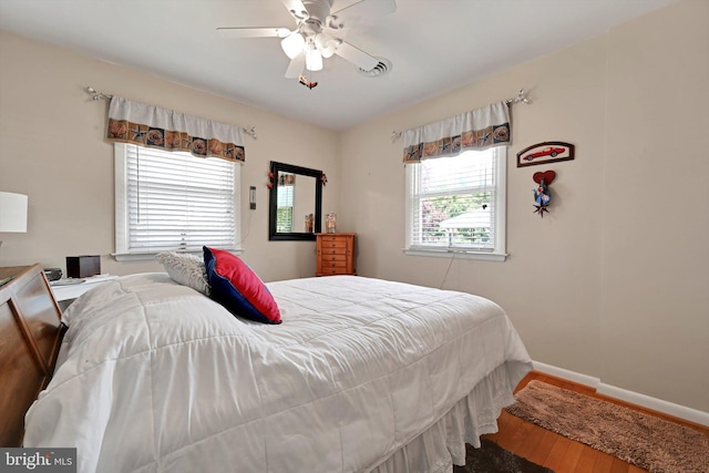 bedroom with wood finished floors, baseboards, and ceiling fan