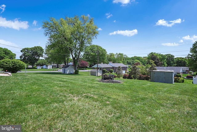 view of green lawn featuring a storage unit and an outdoor structure