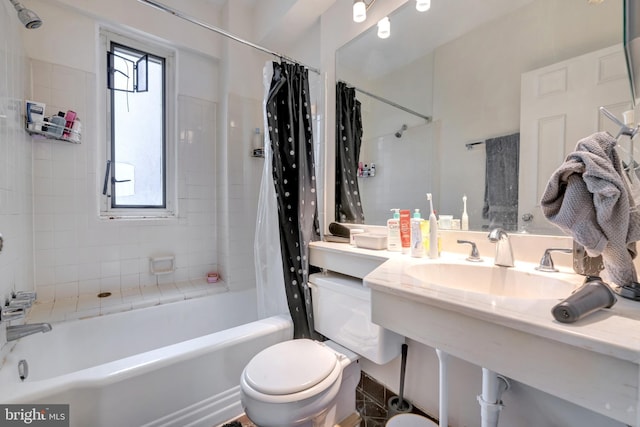 bathroom with shower / bathtub combination with curtain, toilet, and a sink