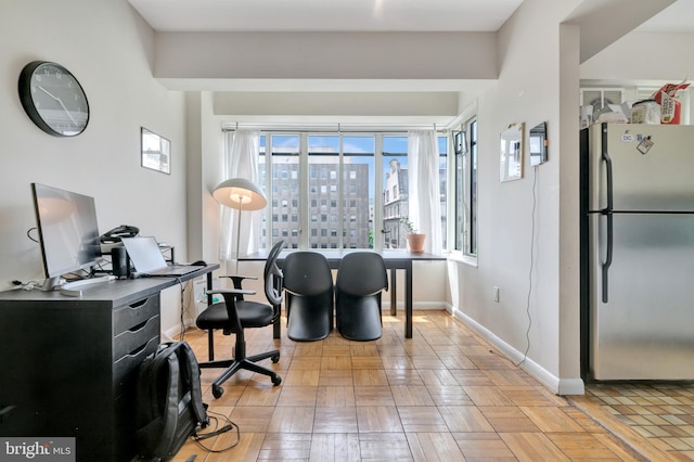 office space featuring healthy amount of natural light, baseboards, and a city view
