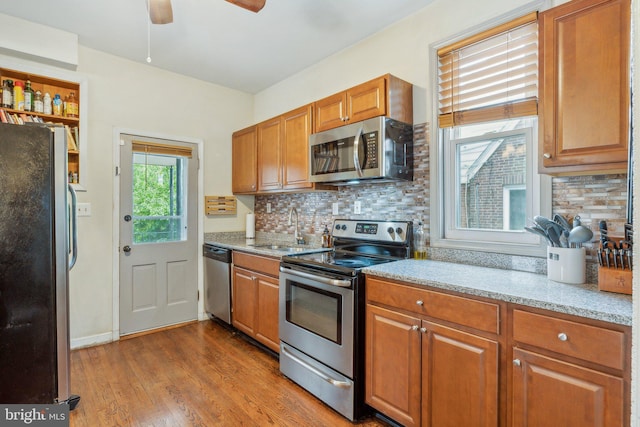5207 Eugene Ave, Baltimore, MD 21206 - kitchen featuring stainless steel appliances, a sink, decorative backsplash, wood finished floors, and ceiling fan