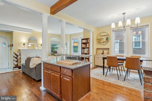 5207 Eugene Ave, Baltimore, MD 21206 - kitchen with wood-type flooring, light stone countertops, open floor plan, beam ceiling, and ornate columns