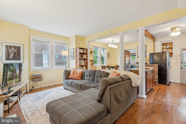 5207 Eugene Ave, Baltimore, MD 21206 - living room with decorative columns, wood finished floors, baseboards, and ceiling fan