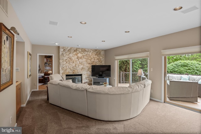 carpeted living room with a fireplace, baseboards, and recessed lighting