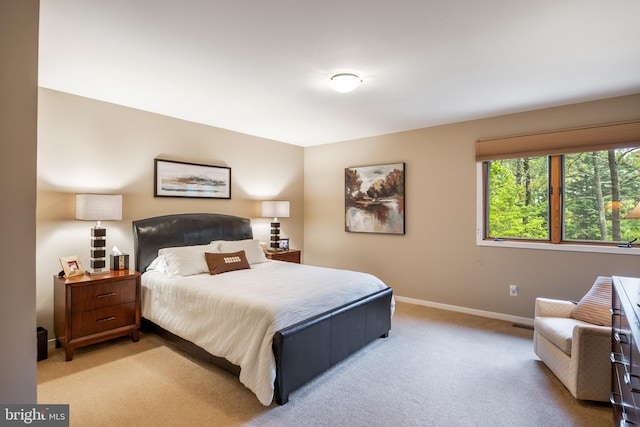 bedroom featuring light colored carpet and baseboards