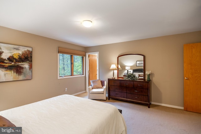 bedroom with light carpet and baseboards