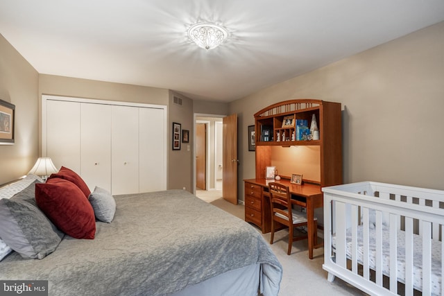 bedroom with light colored carpet, a closet, and an office area
