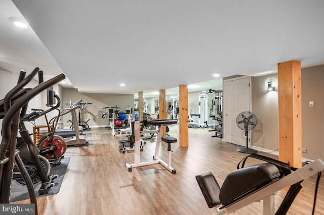 workout area featuring light wood-style flooring, baseboards, and recessed lighting