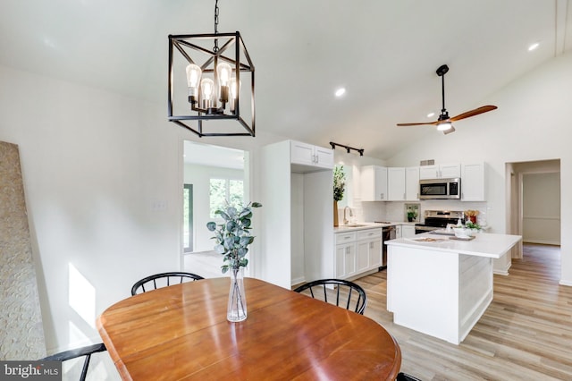 1017 Mill Rd, Leesport, PA 19533 - dining area featuring light wood-style flooring, ceiling fan, a chandelier, high vaulted ceiling, and baseboards