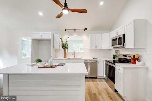 1017 Mill Rd, Leesport, PA 19533 - kitchen featuring appliances with stainless steel finishes, a sink, tasteful backsplash, white cabinets, and vaulted ceiling