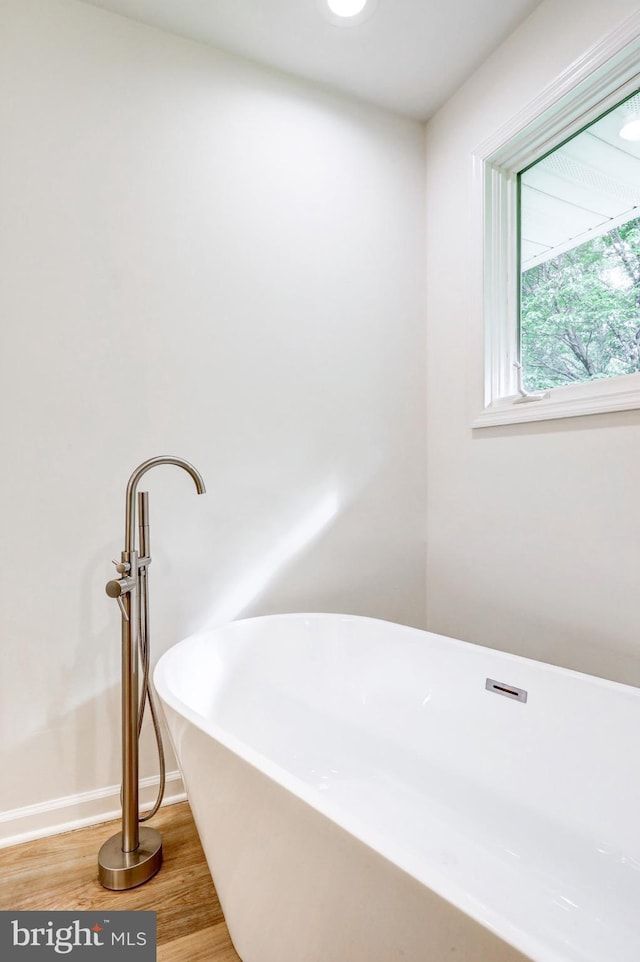 1017 Mill Rd, Leesport, PA 19533 - bathroom featuring a soaking tub, wood finished floors, and baseboards