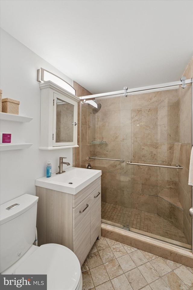 full bath featuring toilet, a shower stall, and vanity