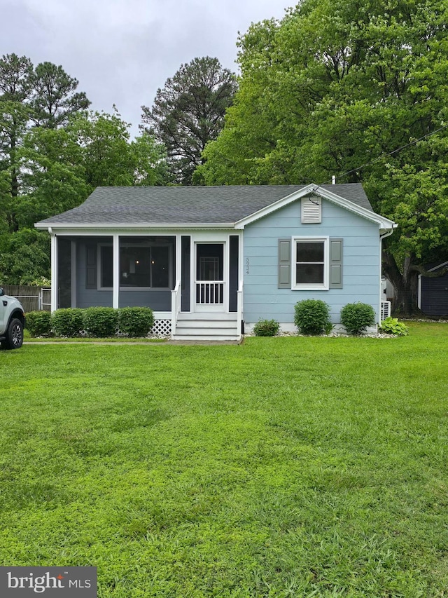 5934 Tilghman Island Rd, Tilghman, MD 21671 - view of front of property with a front yard, a shingled roof, and a sunroom