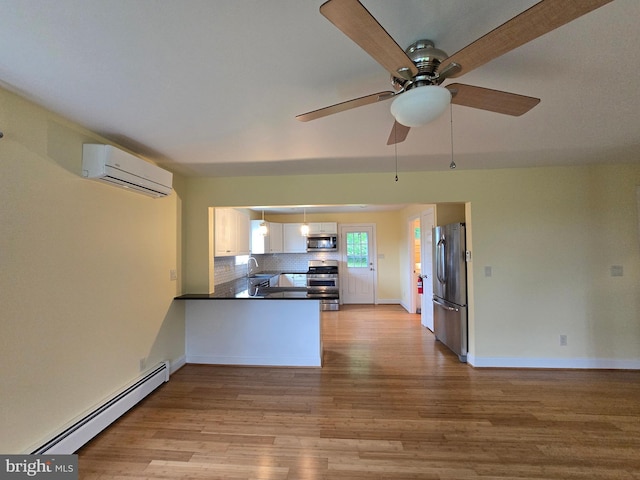 5934 Tilghman Island Rd, Tilghman, MD 21671 - kitchen featuring stainless steel appliances, an AC wall unit, a baseboard heating unit, a sink, and light wood-style floors