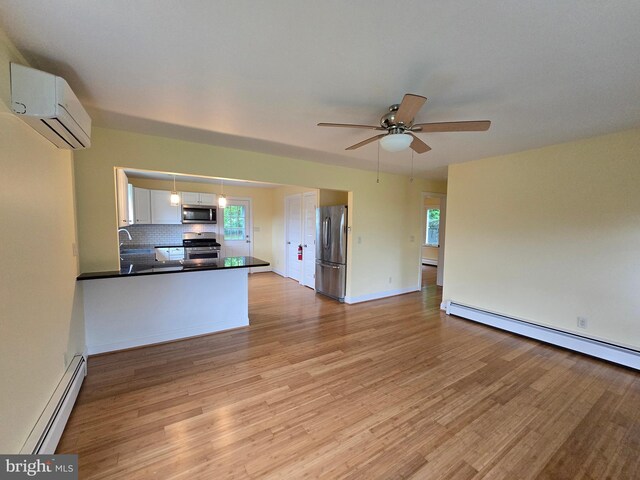 5934 Tilghman Island Rd, Tilghman, MD 21671 - unfurnished living room featuring a wall mounted AC, baseboard heating, light wood-type flooring, and plenty of natural light