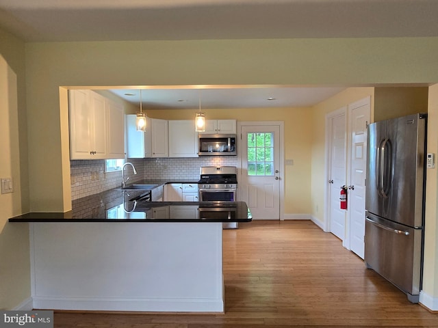 5934 Tilghman Island Rd, Tilghman, MD 21671 - kitchen featuring appliances with stainless steel finishes, baseboards, dark countertops, white cabinets, and tasteful backsplash
