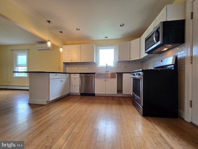 5934 Tilghman Island Rd, Tilghman, MD 21671 - kitchen with stainless steel appliances, a wall mounted AC, a baseboard radiator, dark countertops, and a peninsula