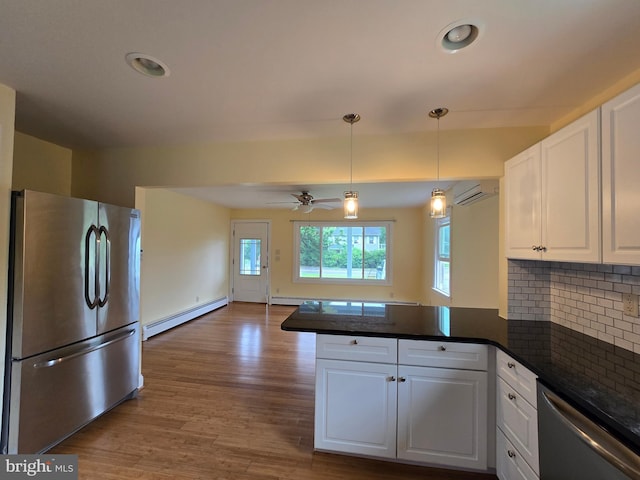 5934 Tilghman Island Rd, Tilghman, MD 21671 - kitchen featuring appliances with stainless steel finishes, a baseboard heating unit, a peninsula, white cabinets, and a wall mounted air conditioner