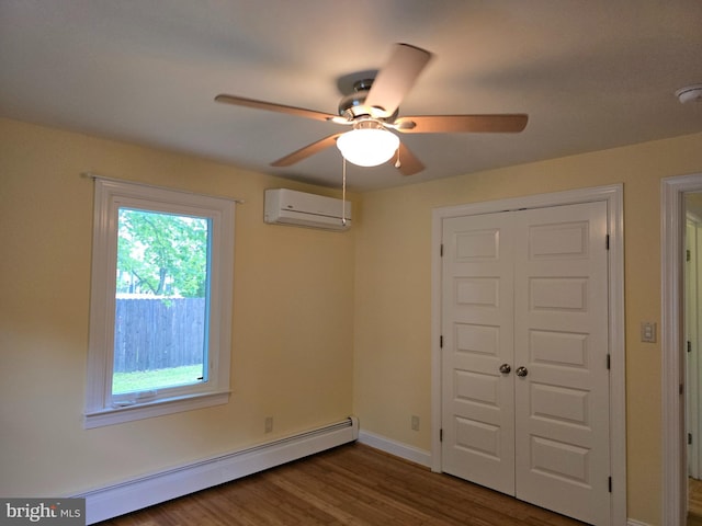 5934 Tilghman Island Rd, Tilghman, MD 21671 - unfurnished bedroom featuring a baseboard heating unit, a wall mounted air conditioner, a closet, wood finished floors, and a ceiling fan