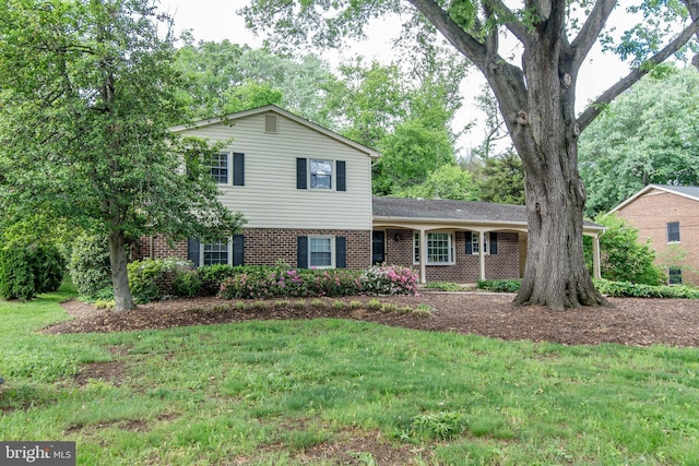tri-level home with brick siding and a front yard