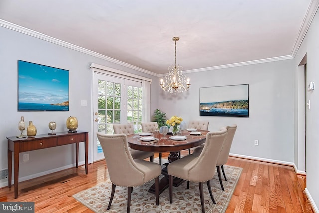 dining room featuring a chandelier, light wood-style floors, crown molding, and baseboards
