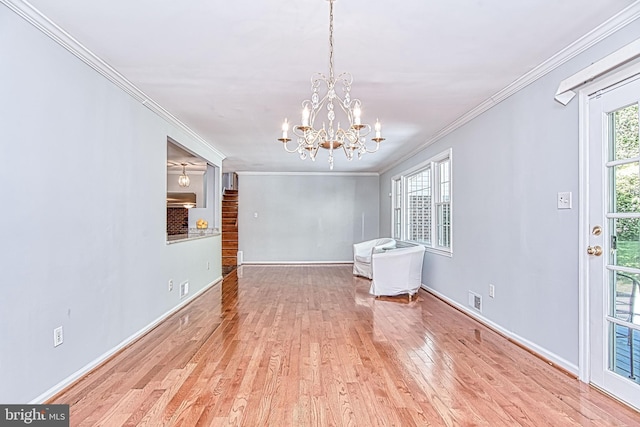 unfurnished dining area featuring crown molding, wood finished floors, a chandelier, and baseboards