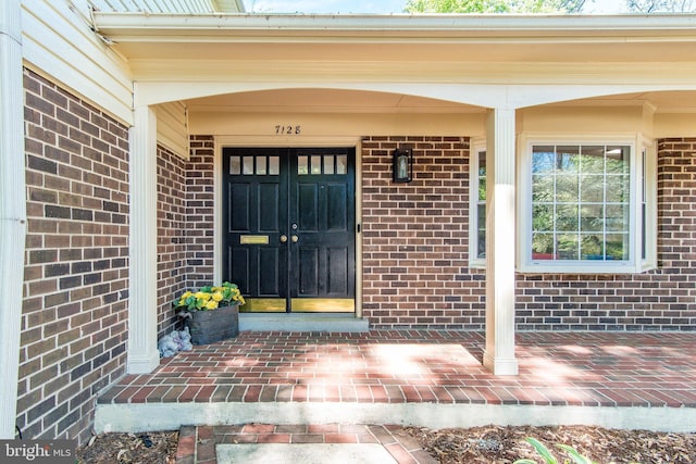 property entrance featuring brick siding and covered porch