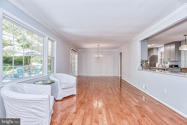 dining space with a chandelier, light wood-style flooring, crown molding, and baseboards