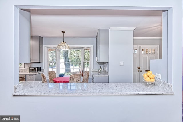 kitchen featuring gray cabinets, light stone counters, decorative light fixtures, and dishwasher