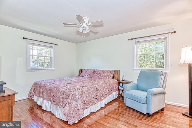 bedroom with light wood-style flooring, baseboards, and a ceiling fan