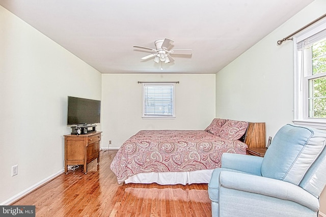 bedroom featuring wood finished floors, baseboards, and a ceiling fan