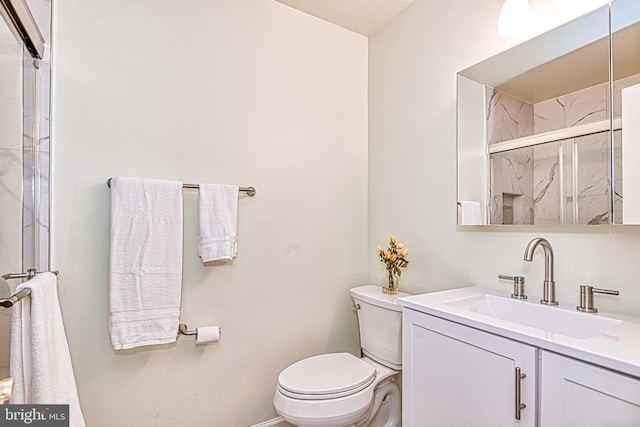 bathroom featuring toilet, a shower with door, baseboards, and vanity