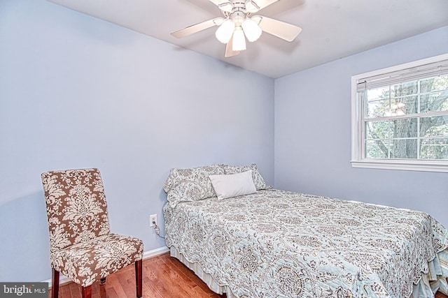bedroom with wood finished floors, baseboards, and a ceiling fan