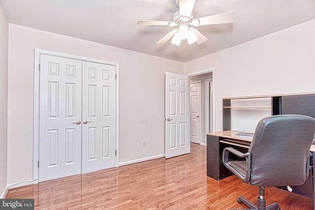 office area with a ceiling fan, light wood-type flooring, and baseboards