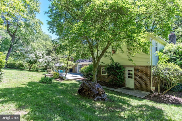view of grassy yard with a deck