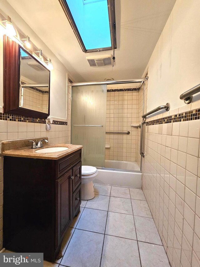 1506 N 13th St, Philadelphia, PA 19122 - bathroom featuring tile walls, vanity, toilet, and combined bath / shower with glass door