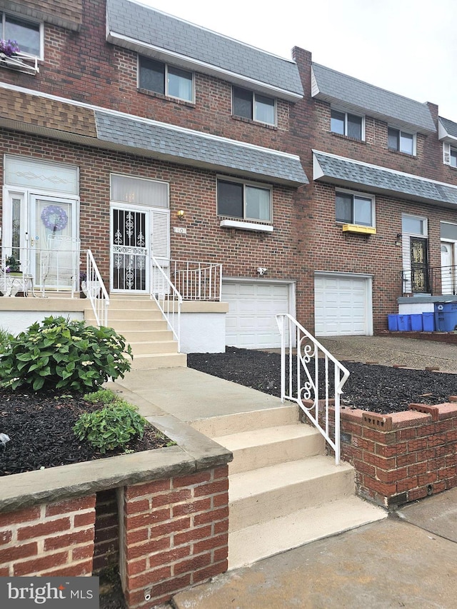 1506 N 13th St, Philadelphia, PA 19122 - view of front of property featuring brick siding, an attached garage, roof with shingles, and mansard roof
