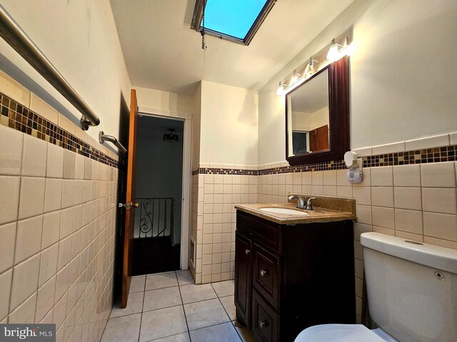 1506 N 13th St, Philadelphia, PA 19122 - bathroom featuring tile walls, tile patterned floors, wainscoting, toilet, and vanity
