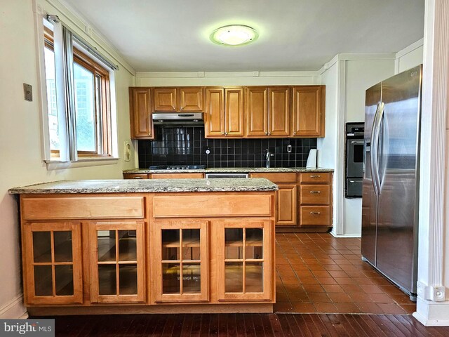 1506 N 13th St, Philadelphia, PA 19122 - kitchen featuring appliances with stainless steel finishes, brown cabinets, under cabinet range hood, and decorative backsplash