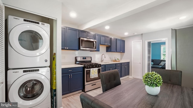 1802 Kittyhawk Rd, Baltimore, MD 21221 - kitchen with stainless steel appliances, stacked washing machine and dryer, a sink, light wood-type flooring, and light countertops