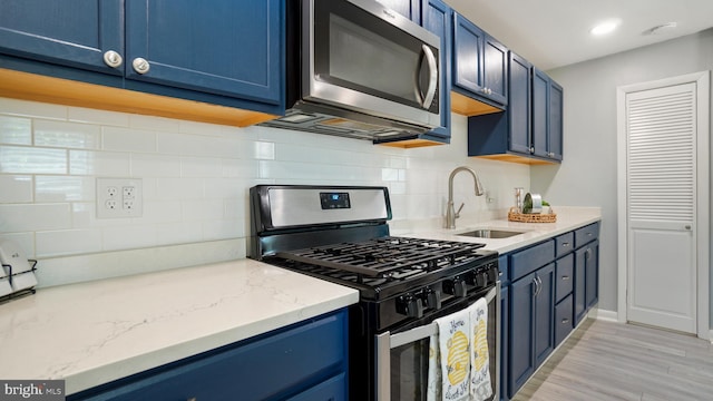 1802 Kittyhawk Rd, Baltimore, MD 21221 - kitchen featuring stainless steel appliances, blue cabinets, a sink, and decorative backsplash