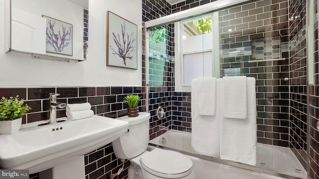 1802 Kittyhawk Rd, Baltimore, MD 21221 - bathroom featuring tile walls, a sink, toilet, tiled shower / bath, and wainscoting