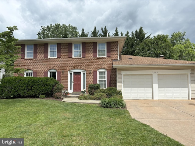 colonial home with a garage, driveway, brick siding, and a front yard