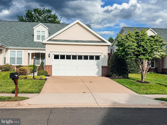 view of front of property featuring brick siding, a front yard, an attached garage, and driveway