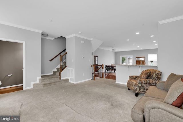 carpeted living area with crown molding, recessed lighting, baseboards, ceiling fan, and stairway
